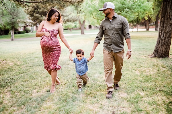 Alexis with her husband and son walking in a park